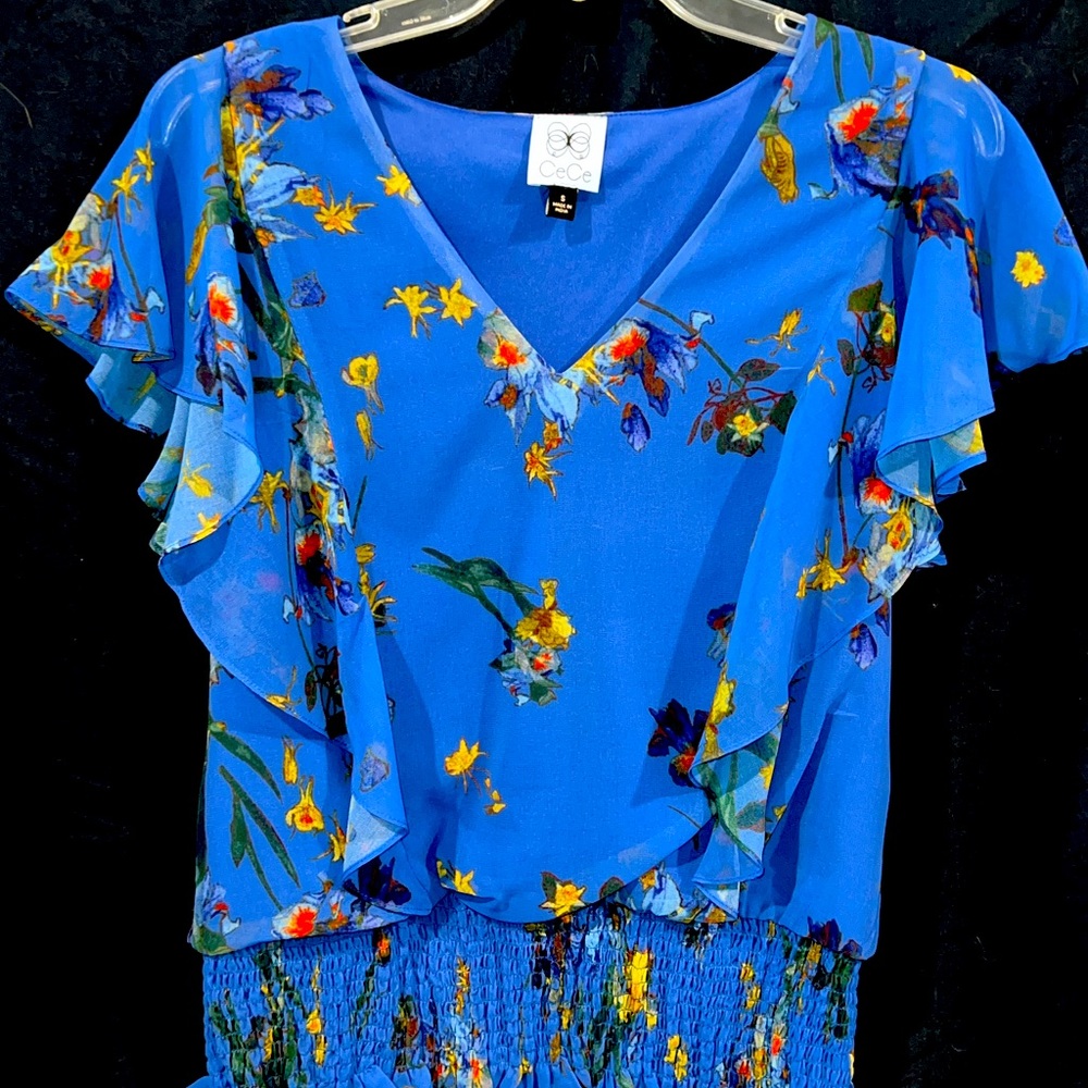 CeCe ruffled floral patterned blouse with short ruffled sleeves.